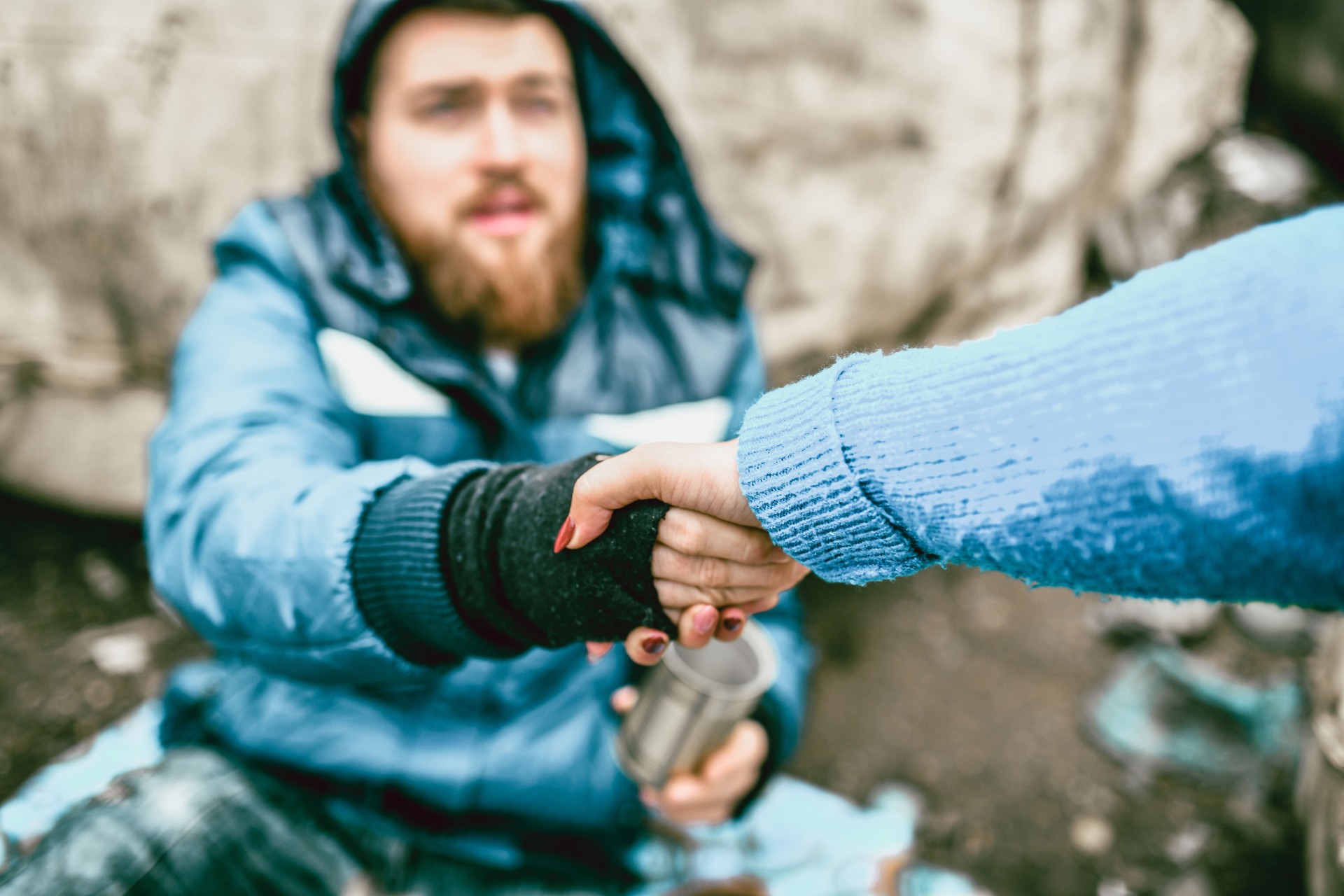 Female Offering Support For Homeless Male On Street